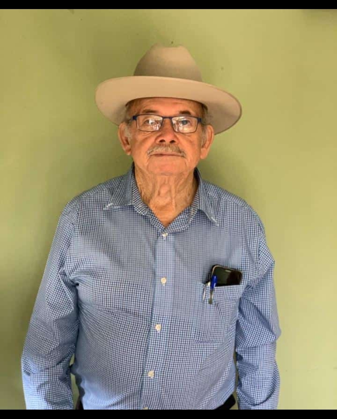 Abuelo de la familia Café Dams de pie con sombrero y camisa de cuadros